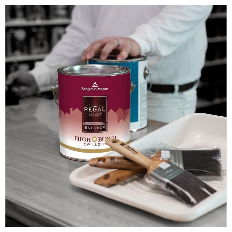 paint contractor at paint store sales counter purchasing a gallon of Regal Exterior Low Lustre Paint, paint brushes, and tray liners
